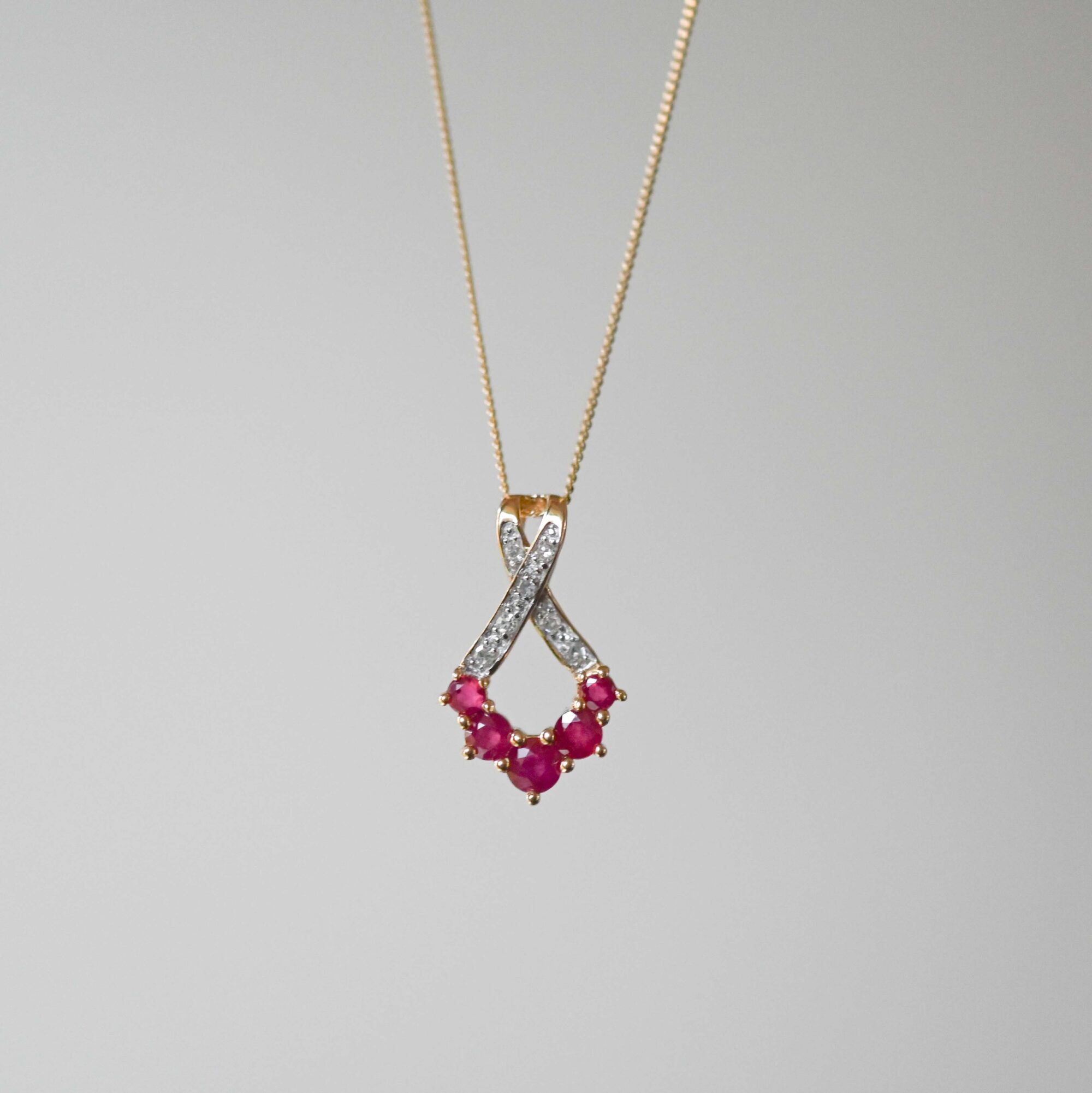 Contemporary 9ct gold graduated ruby and mini diamond pendant necklace