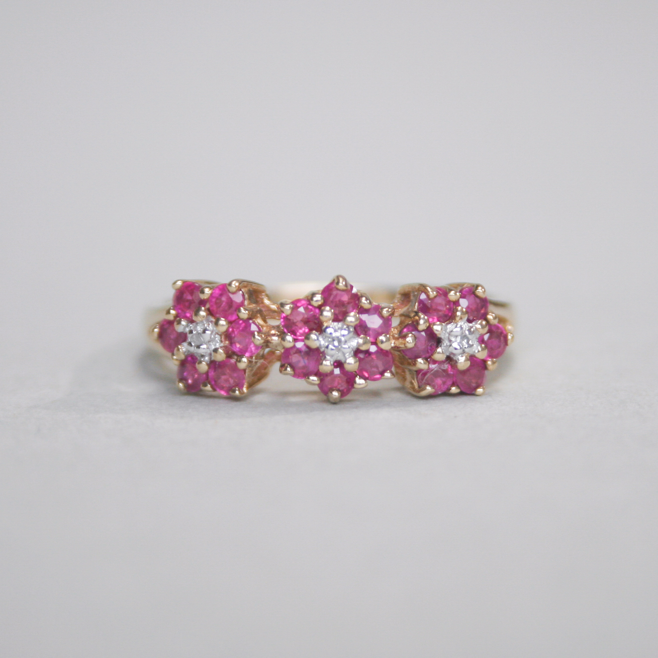 Contemporary 9ct gold ruby and mini diamond triple cluster ring